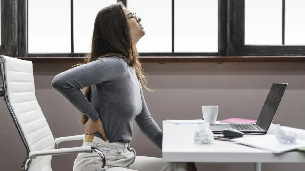 side view woman having backache while working from home scaled