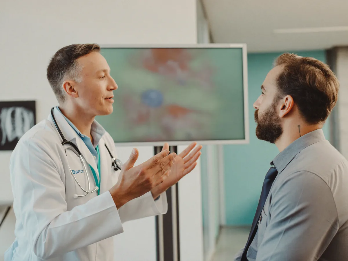 A urologist reviewing an abdominal scan with a patient during a kidney stone consultation at German Medical Center Dubai