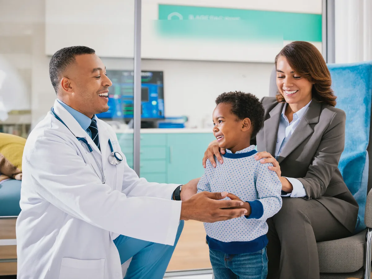 A pediatric specialist greeting a young child and parent at German Medical Center Dubai